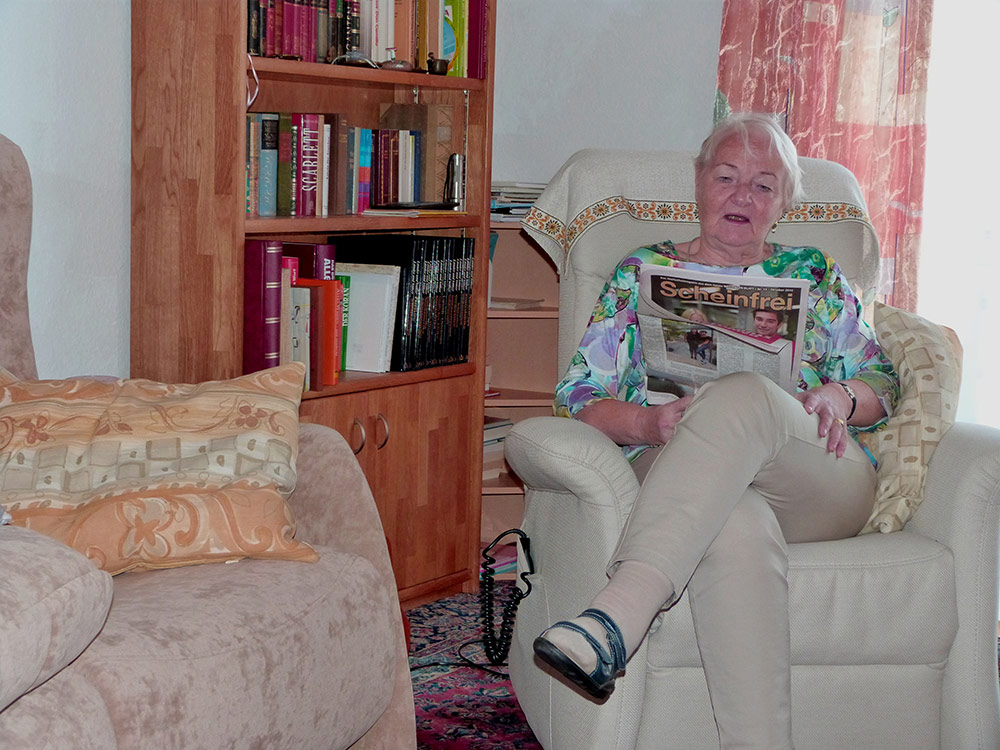 Eine Frau beim Lesen in Ihrem Wohnzimmer